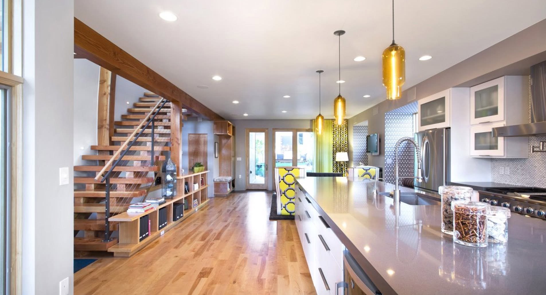 Open-plan kitchen and stairway with recessed lighting and pendant lights installed by N3 Electrical Services