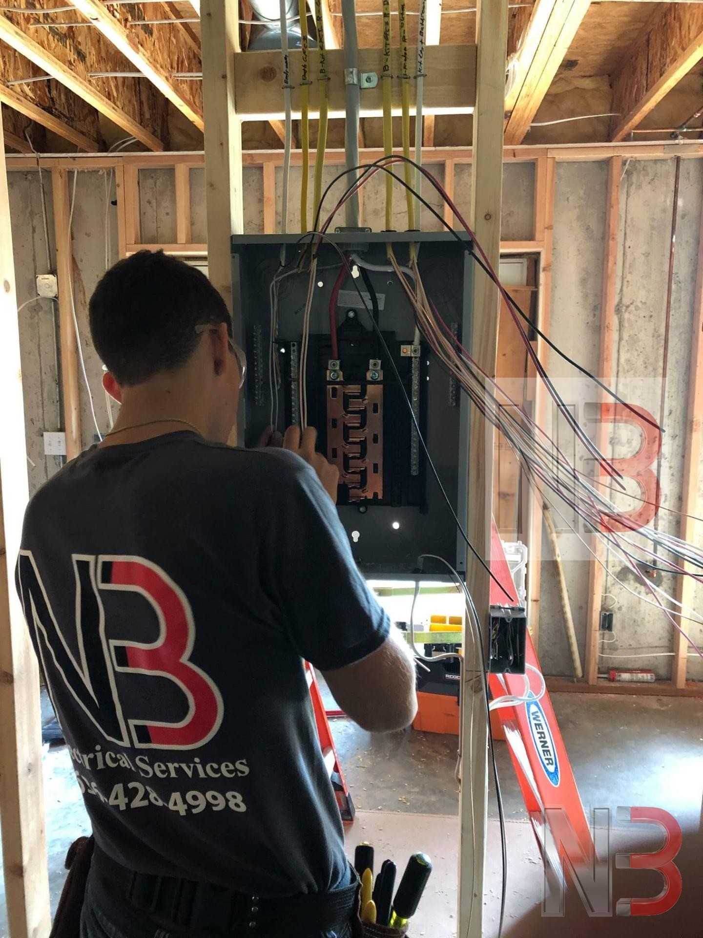 N3 Electrical Services technician wiring a new breaker panel during construction